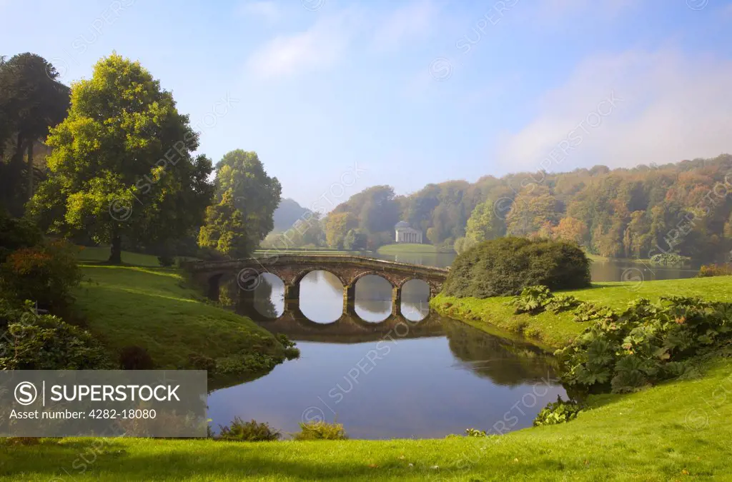 England, Wiltshire, Warminster. Henry Hoare's Palladian Bridge reflecting in the lake at Stourhead Gardens on a fine autumn day.