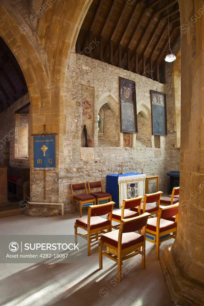 England, Somerset, Stoke St Gregory. View of chairs arranged in front of a small altar in Saint Gregory's church.