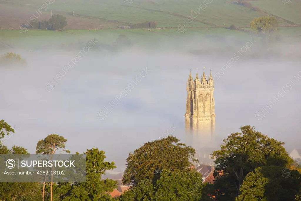 England, Somerset, Glastonbury. The steeple of St John the Baptist church surrounded by mist, viewed from the top of Glastonbury Tor.