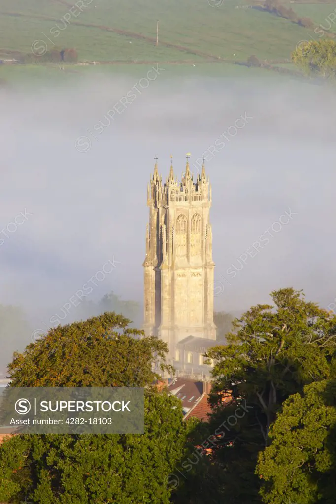 England, Somerset, Glastonbury. The steeple of St John the Baptist church surrounded by mist, viewed from the top of Glastonbury Tor.