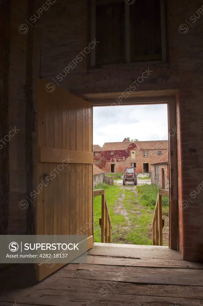England, Somerset, Taunton. View of farmyard through an open door of a restored Tythe barn.