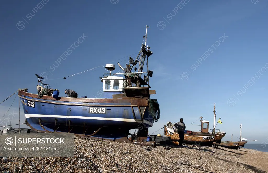England, Kent, Dungeness. Boats on Dungeness beach. Dungeness consists of a complex of shingle and marsh situated along a 38-km stretch of coastline in Kent and East Sussex containing a classic sequence of shingle beaches.