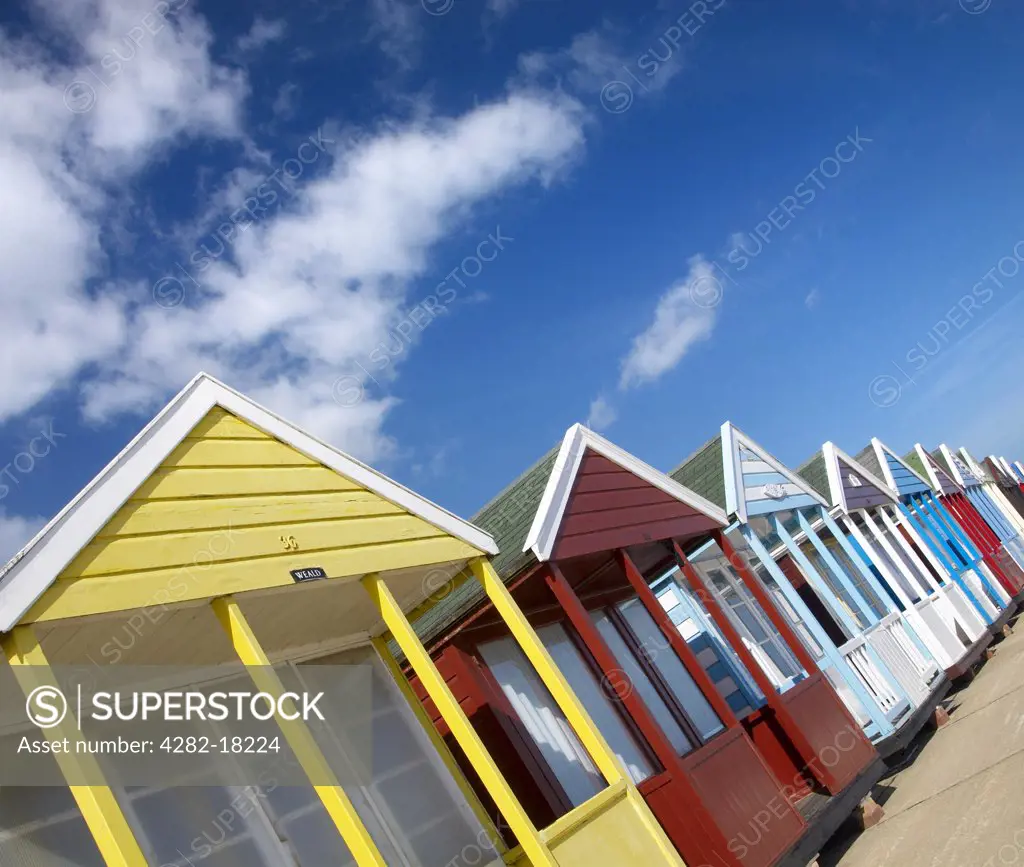 England, Suffolk, Southwold. A row of beach huts on Southwold promenade.