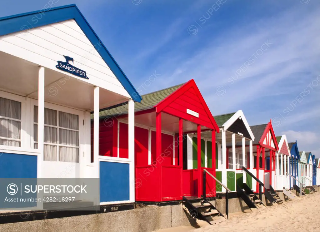 England, Suffolk, Southwold. Colourful beach huts along the seafront in Southwold.