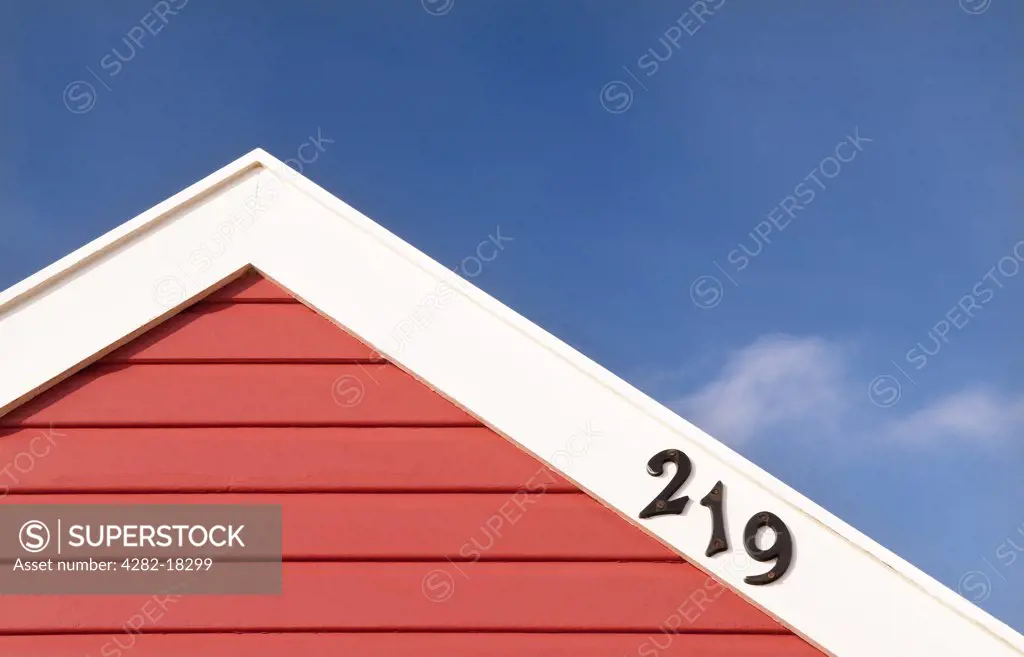 England, Suffolk, Southwold. The top of a colourful red beach hut displaying its number, in Southwold.