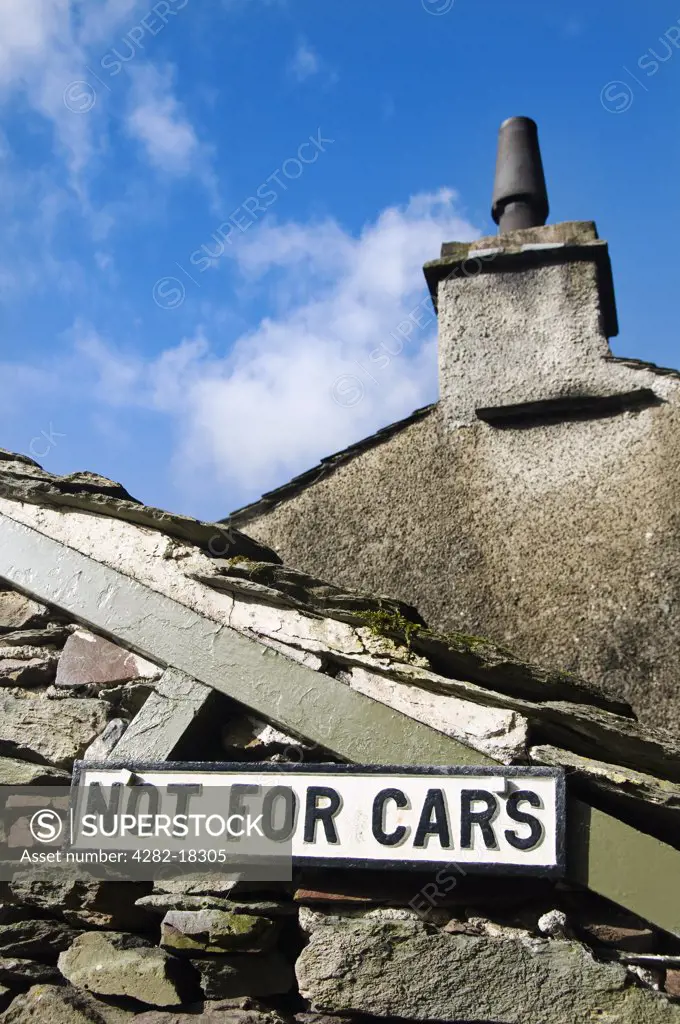 England, Cumbria, near Grasmere. ""Not for cars"" sign on a building along the path from Grasmere to Easdale Tarn in the Lake District.