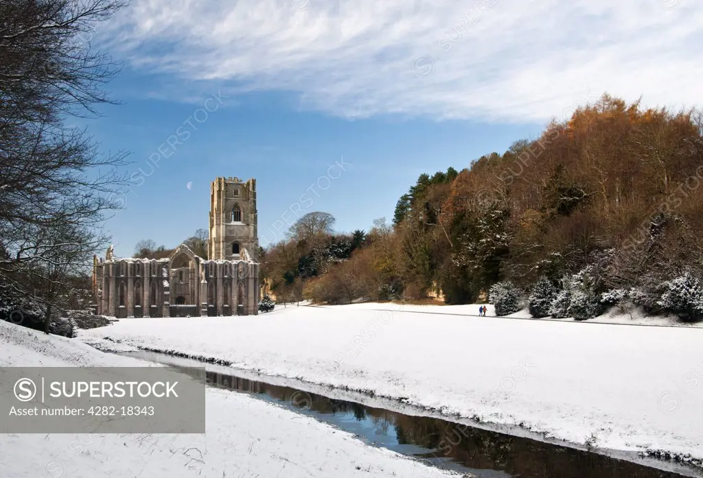 England, North Yorkshire, Fountains Abbey. Snow covering the ground around the 12th century ruins of Fountains Abbey, the largest monastic ruins in England.