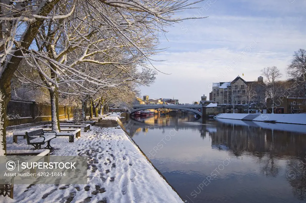 England, North Yorkshire, York. View along Riverside Walk and the River Ouse towards Lendal Bridge in winter.
