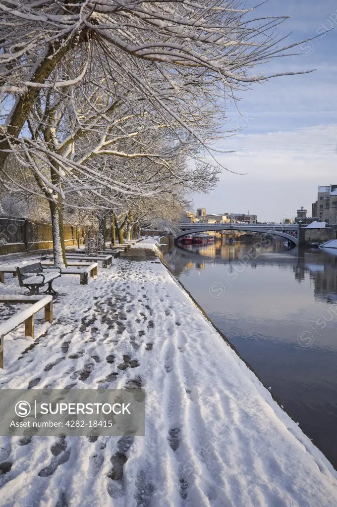 England, North Yorkshire, York. View along Riverside Walk and the River Ouse towards Lendal Bridge in winter.