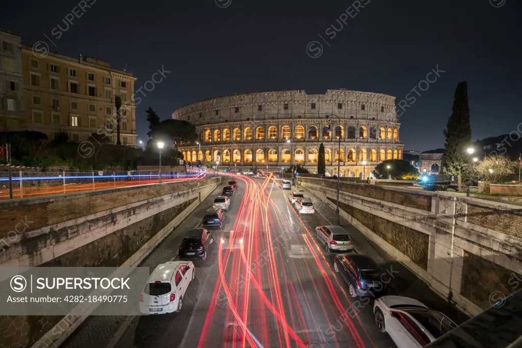 Traffic paints light trails as it speeds past the Colosseum in Rome in Italy.