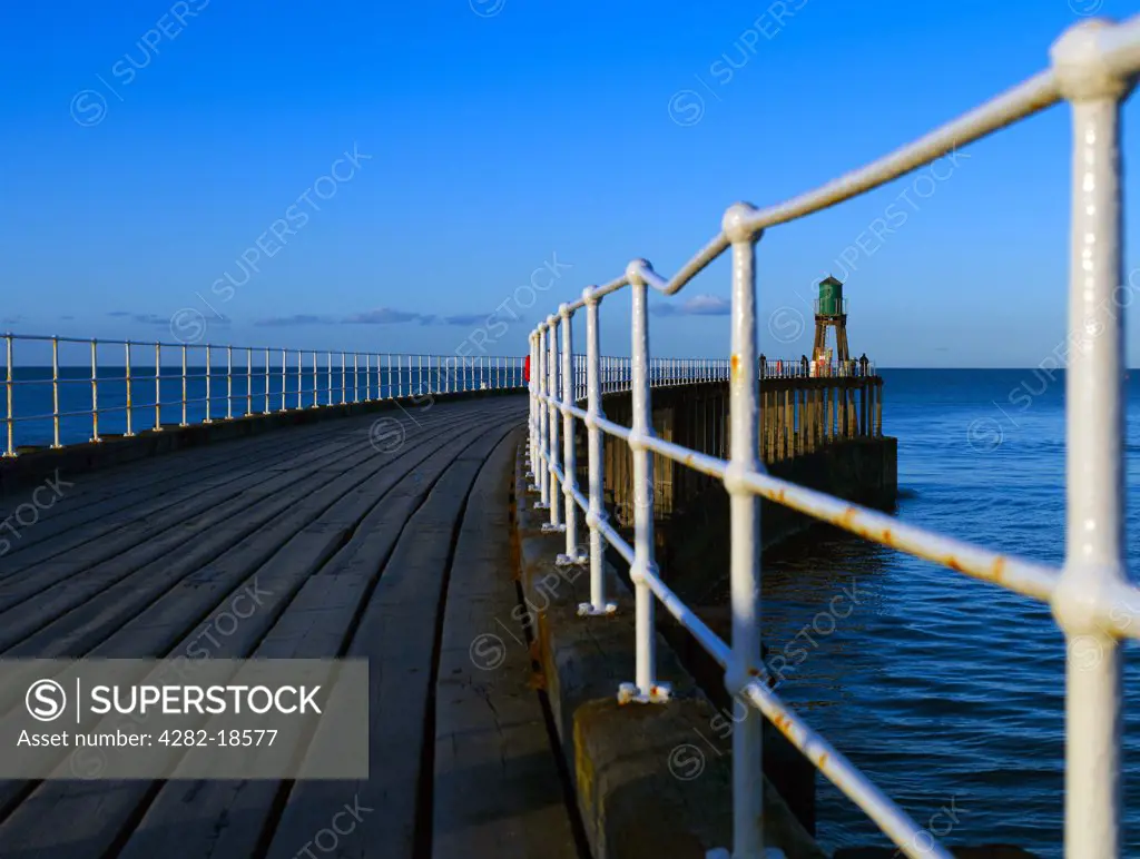 England, North Yorkshire, Whitby. Fisherman at the end of the West Pier by Whitby West Pier Light (New), built in 1914 after the extension of the pier.