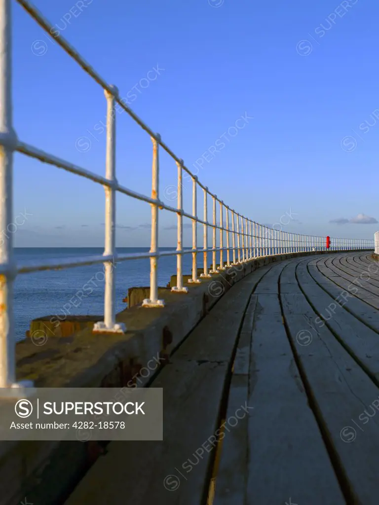 England, North Yorkshire, Whitby. View along the wooden decking of the West Pier out towards the North Sea.