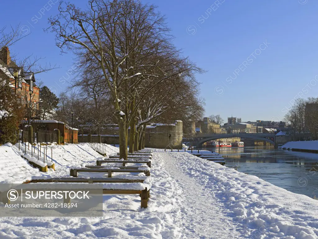 England, North Yorkshire, York. Snow covering the Riverside walk, looking towards Lendal Bridge in winter.