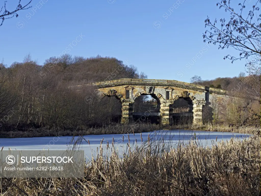 England, North Yorkshire, Castle Howard. New River Bridge built in the 1740's spanning a frozen New River in the gardens of Castle Howard.