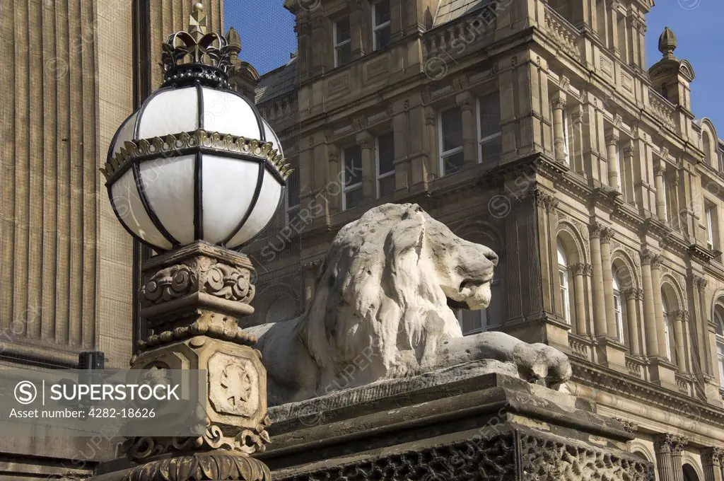 England, West Yorkshire, Leeds. A carved lion on a plinth and ornate lamp outside Leeds Town Hall on The Headrow, the main street in Leeds City Centre.