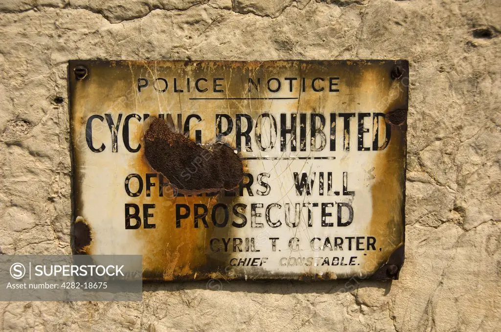 England, North Yorkshire, York. Old rusted enamel police plaque mounted on a stone wall advising cycling prohibited.