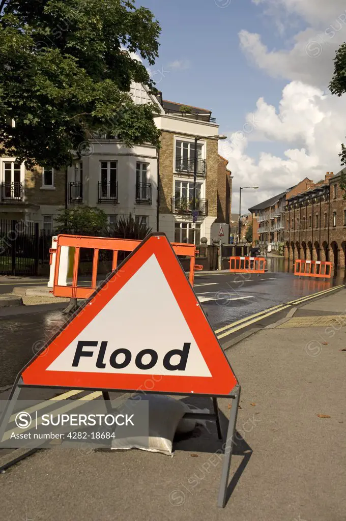England, North Yorkshire, York. Flood warning sign and barriers across road halting traffic due to flooding.