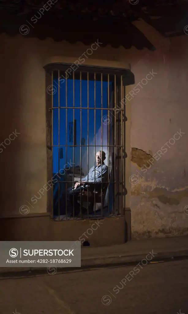 Man in a window in Cuba.