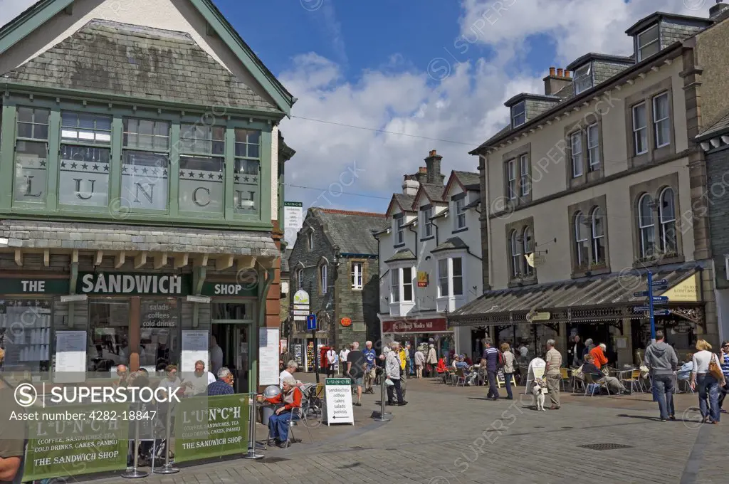 England, Cumbria, Keswick. People eating outside The Sandwich Shop and Bryson's Tea Room in Market Place, Keswick.