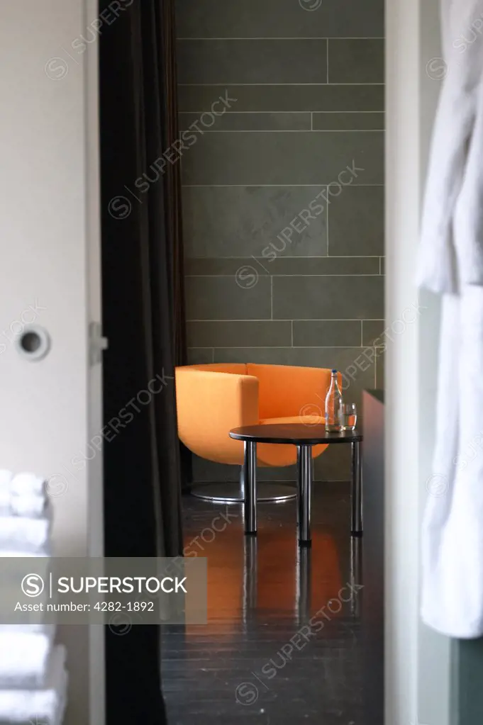 England, London, Covent Garden. An orange chair viewed through a doorway at West Street Hotel.