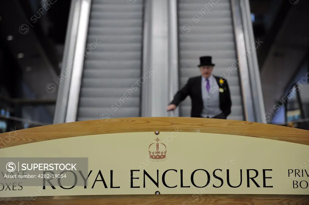 England, Berkshire, Ascot. A man wearing a morning suit and top hat descending an escalator from the private boxes in the Royal Enclosure during day two of Royal Ascot 2010.