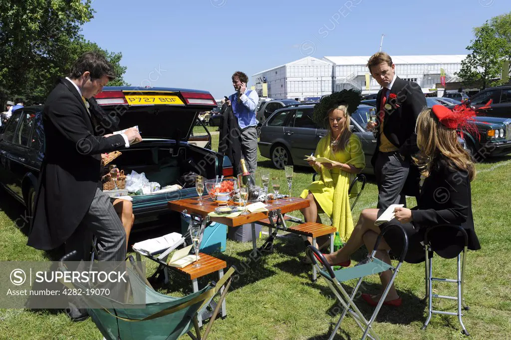 England, Berkshire, Ascot. Smartly dressed racegoers enjoying a picnic lunch in the car park during day two of Royal Ascot 2010.