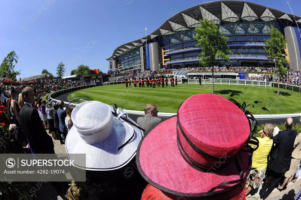 England, Berkshire, Ascot. A large crowd enjoying a performance by a military band in the parade ring on the second day of Royal Ascot 2010.