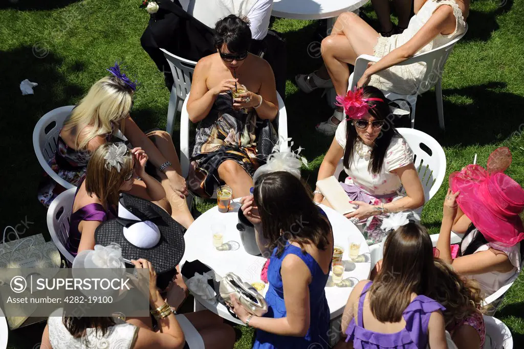 England, Berkshire, Ascot. Smartly dressed women enjoying a glass of Pimms in the grandstand enclosure during day three of Royal Ascot 2010.