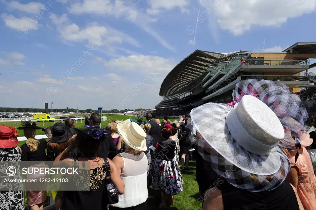 England, Berkshire, Ascot. Smartly dressed racegoers watching a race from the grandstand enclosure during day three of Royal Ascot 2010.