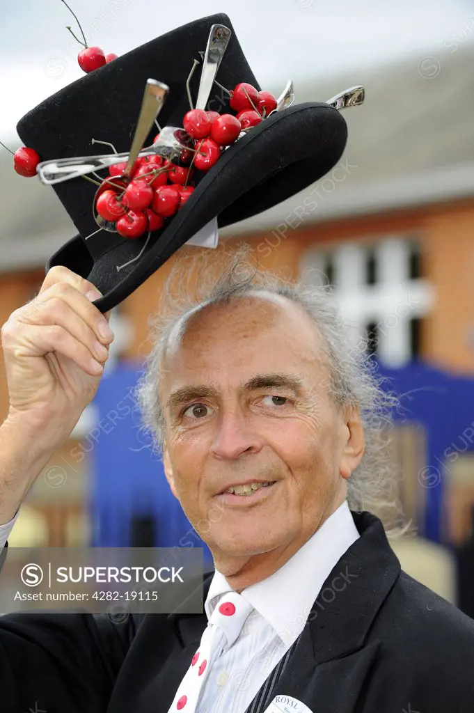 England, Berkshire, Ascot. A male racegoer doffs his top hat decorated with cherries at day one of Royal Ascot.
