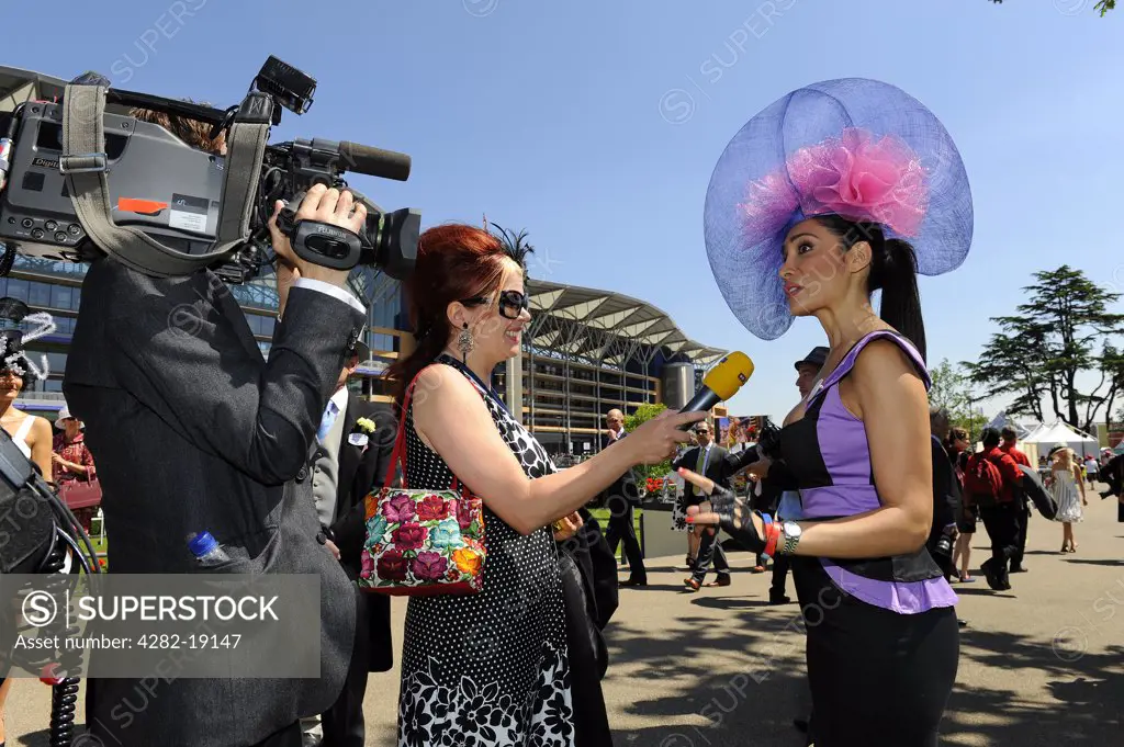 England, Berkshire, Ascot. A well dressed woman interviewed by a TV crew during day three of Royal Ascot 2010.