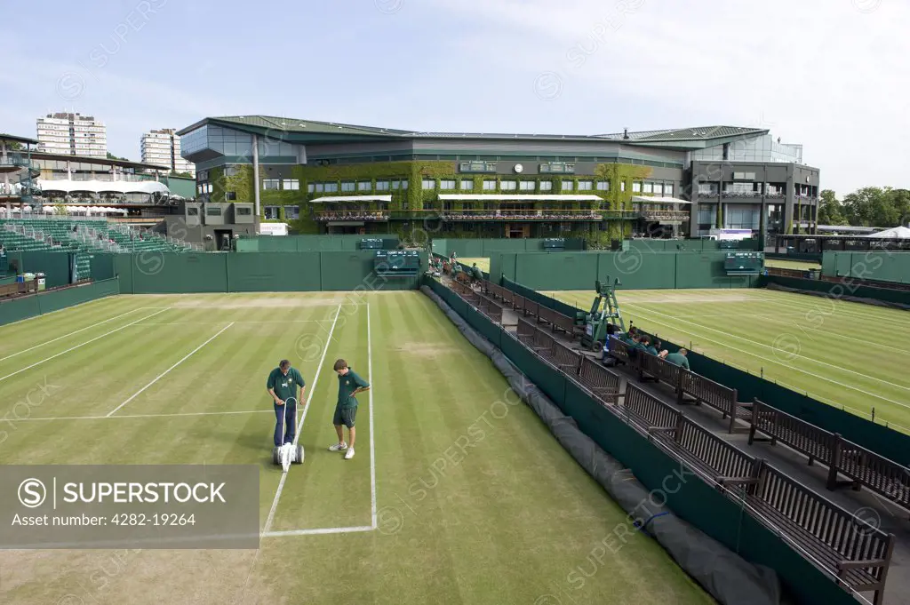 England, London, Wimbledon. Groundsmen painting white lines on Court no. 9 in preparation for a match at the Wimbledon Tennis Championships 2010.