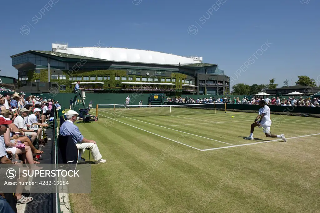 England, London, Wimbledon. Action from a mens singles match on Court 9 with Centre Court in the background at the Wimbledon Tennis Championships 2010.