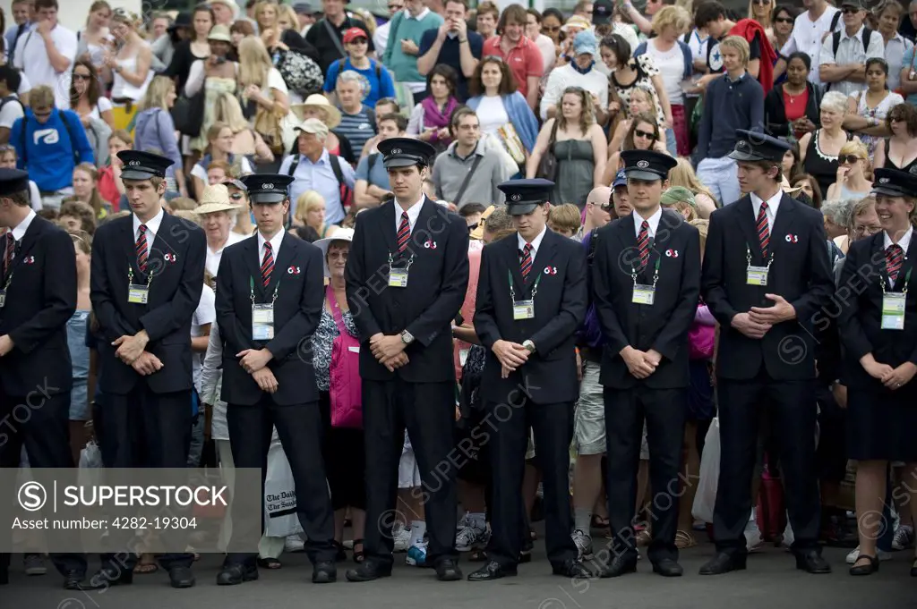 England, London, Wimbledon. G4S security staff in a line to hold back the crowd ahead of the gates opening for the Wimbledon Tennis Championships 2010.