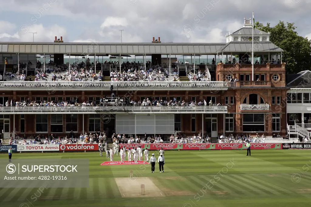 England, London, St Johns Wood. The umpires and players walk out from the Pavilion at Lord's Cricket Ground to commence a test match session.