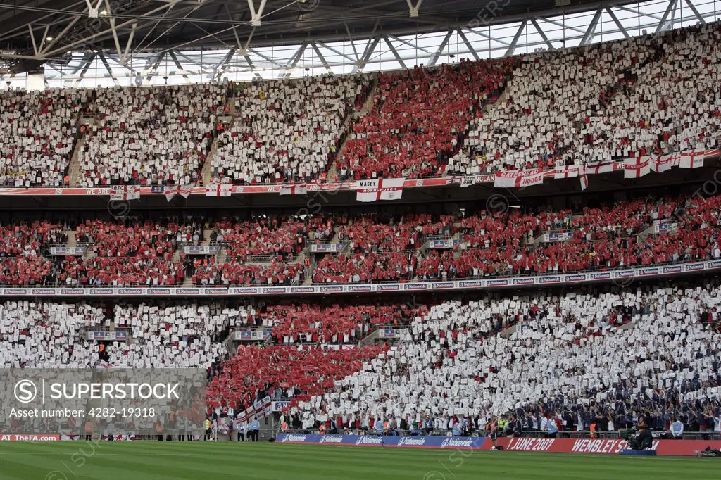 England, London, Wembley. The crowd inside Wembley Stadium holding up cards to make the cross of St. George.