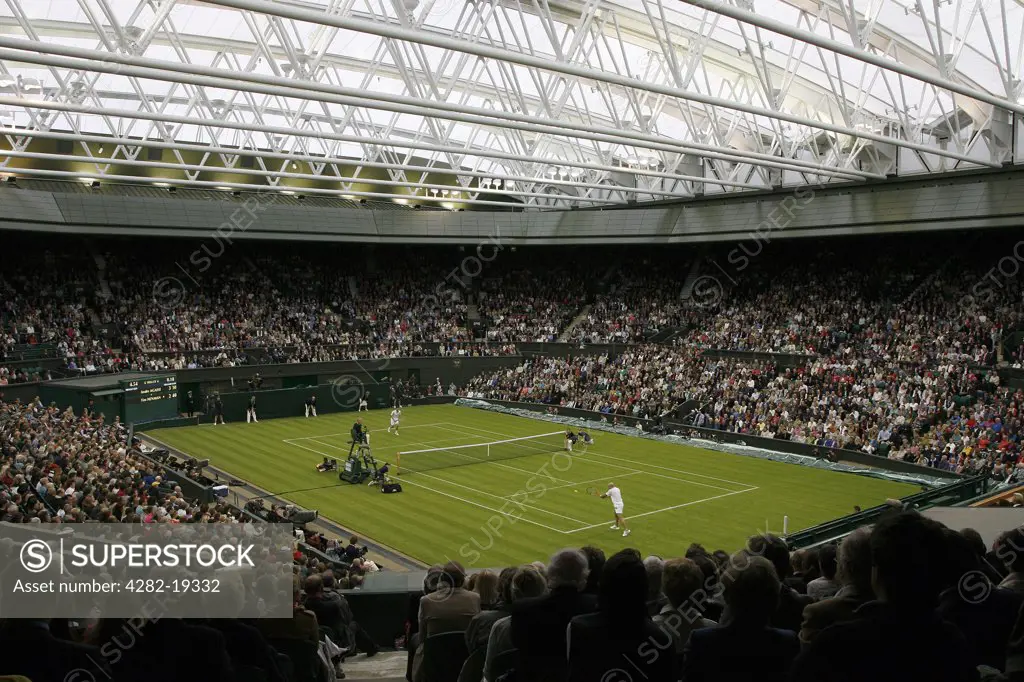 England, London, Wimbledon. A singles match on Centre Court under the new retractable roof during the Wimbledon Centre Court Celebration event.