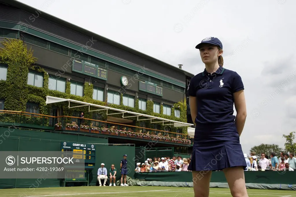 England, London, Wimbledon. A ball girl stands on court 3 with centre court in the background at the Wimbledon Tennis Championships 2008.