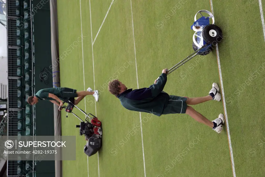 England, London, Wimbledon. The grass is cut and white lines painted on the outside courts during the Wimbledon Tennis Championships 2008.
