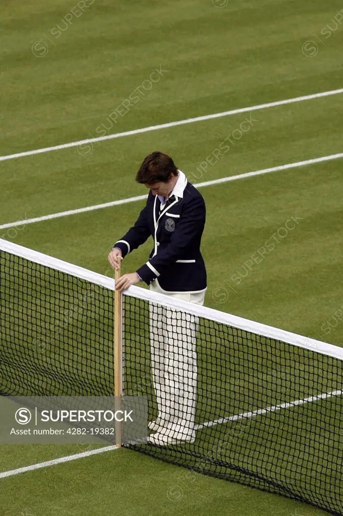 England, London, Wimbledon. An umpire checks the net height during the Wimbledon Tennis Championships 2008.