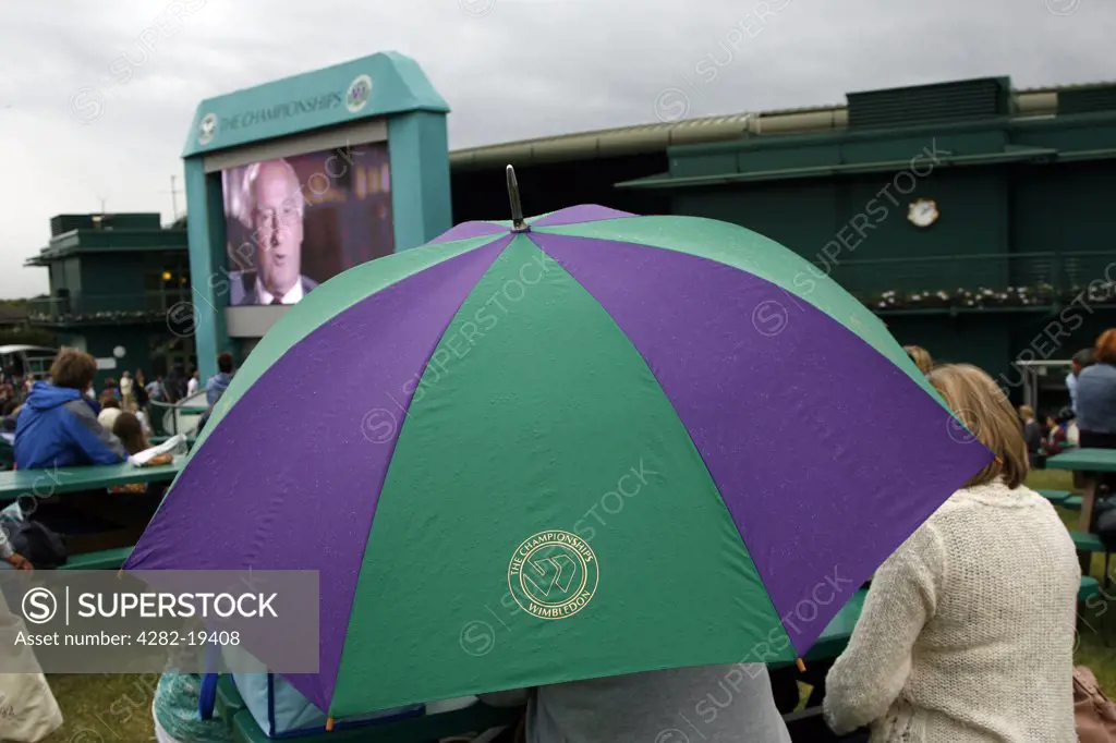 England, London, Wimbledon. Umbrellas go up as rain starts to fall at the Wimbledon Tennis Championships 2008.
