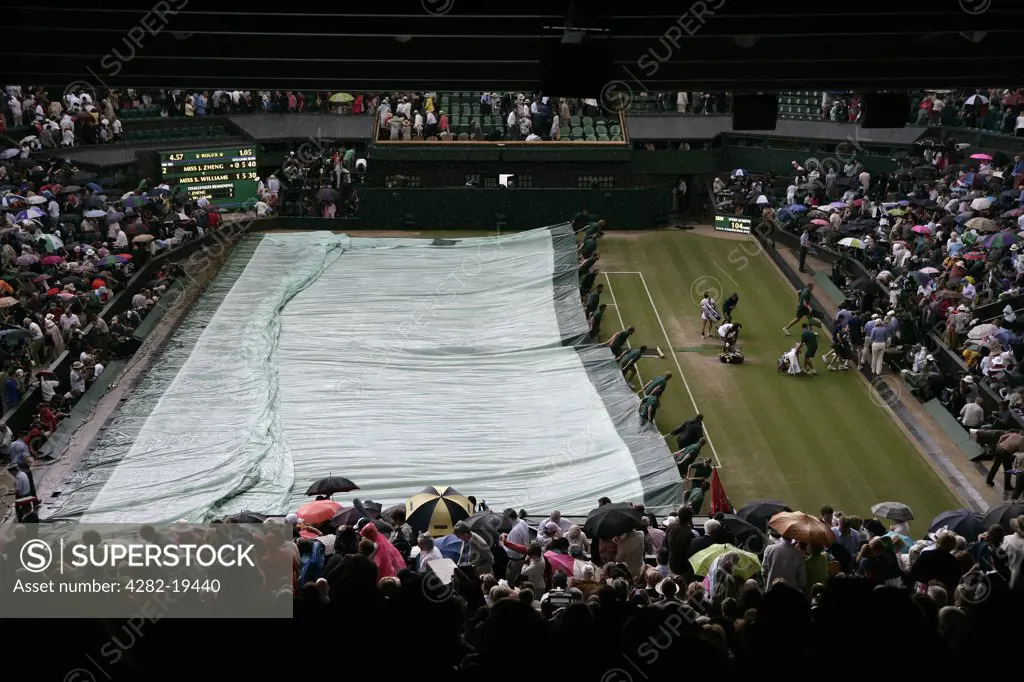 England, London, Wimbledon. The covers are pulled on centre court as the rain starts to fall at the Wimbledon Tennis Championships 2008.