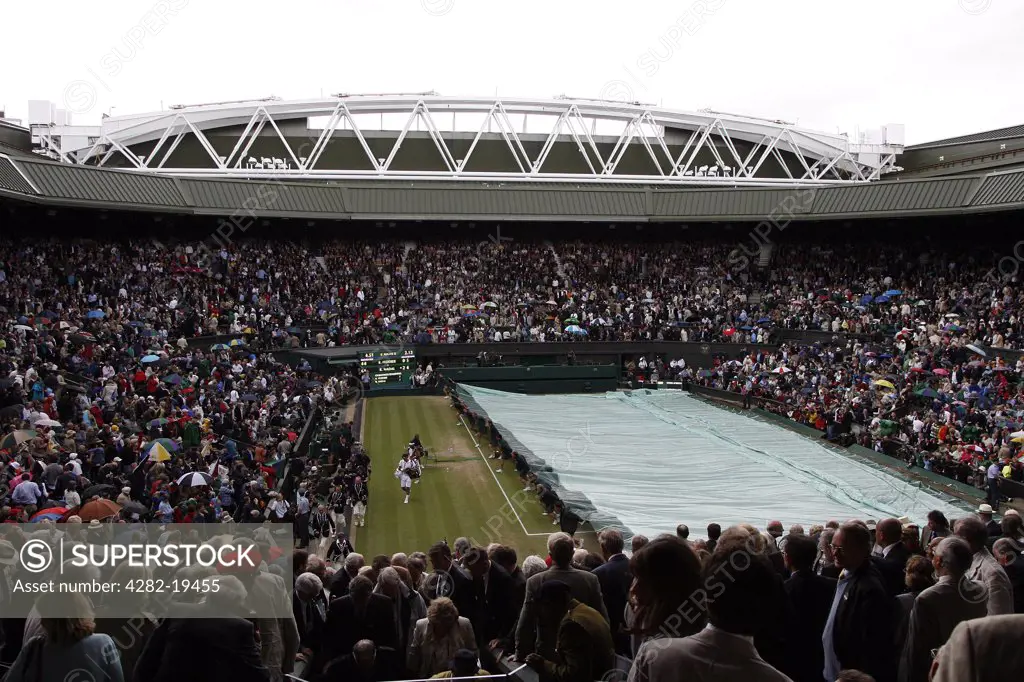 England, London, Wimbledon. View of centre court being covered as rain falls on mens final sunday during the Wimbledon Tennis Championships 2008.