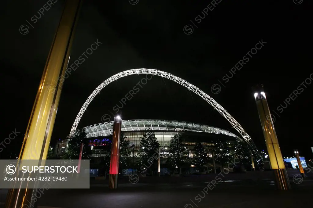 England, London, Wembley. View outside the new Wembley Stadium lit up at night.