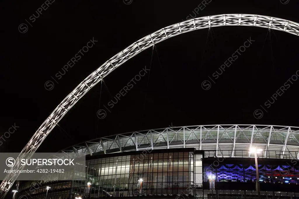 England, London, Wembley. View outside the new Wembley Stadium lit up at night.
