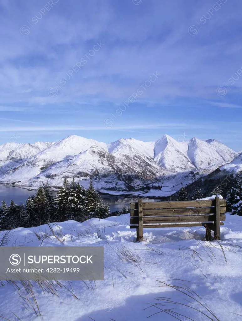 Scotland, Highland, Ratagain Pass. Bench at Bealach Ratagain Viewpoint looking towards the head of Loch Duich and the 'Five Sisters of Kintail' after a heavy snow fall.