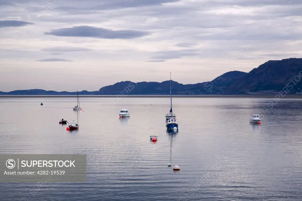 North Wales, Anglesey, Beaumaris. Boats on calm water of Menai Straits with view to Great Orme on North Wales coast from Beaumaris.