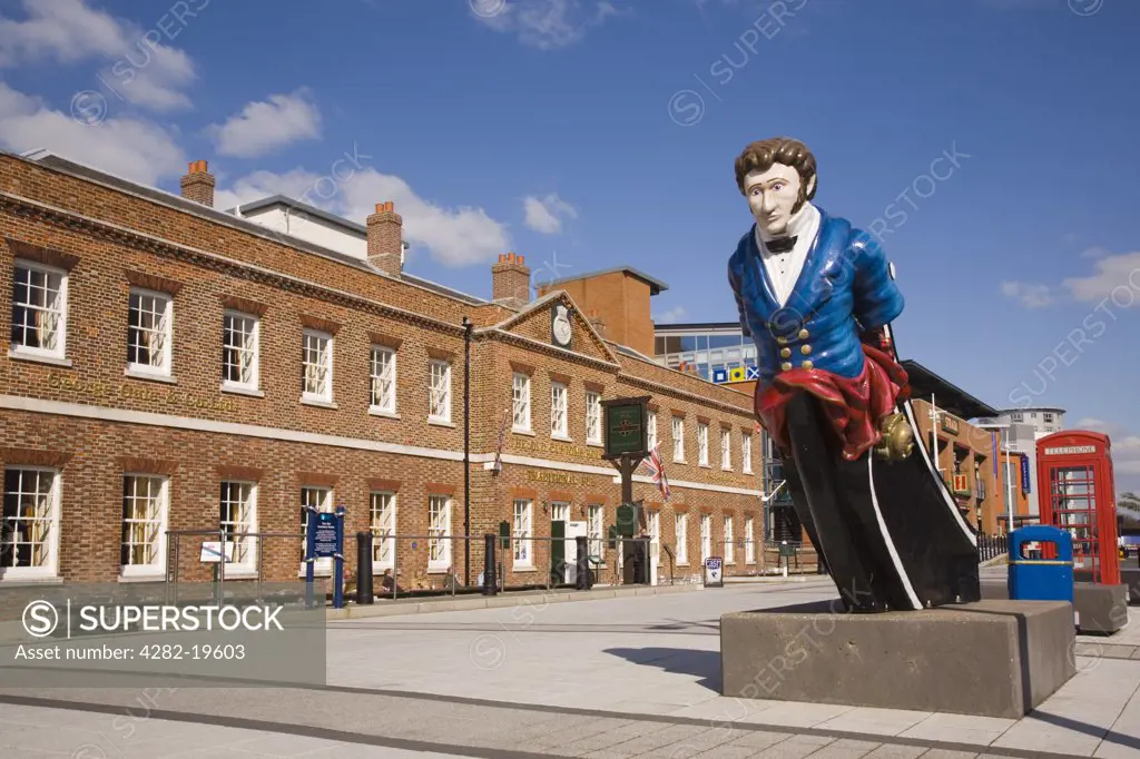 England, Hampshire, Portsmouth. Ship's figurehead in front of the Old Customs House at Gunwharf Quays in regenerated historic harbour.
