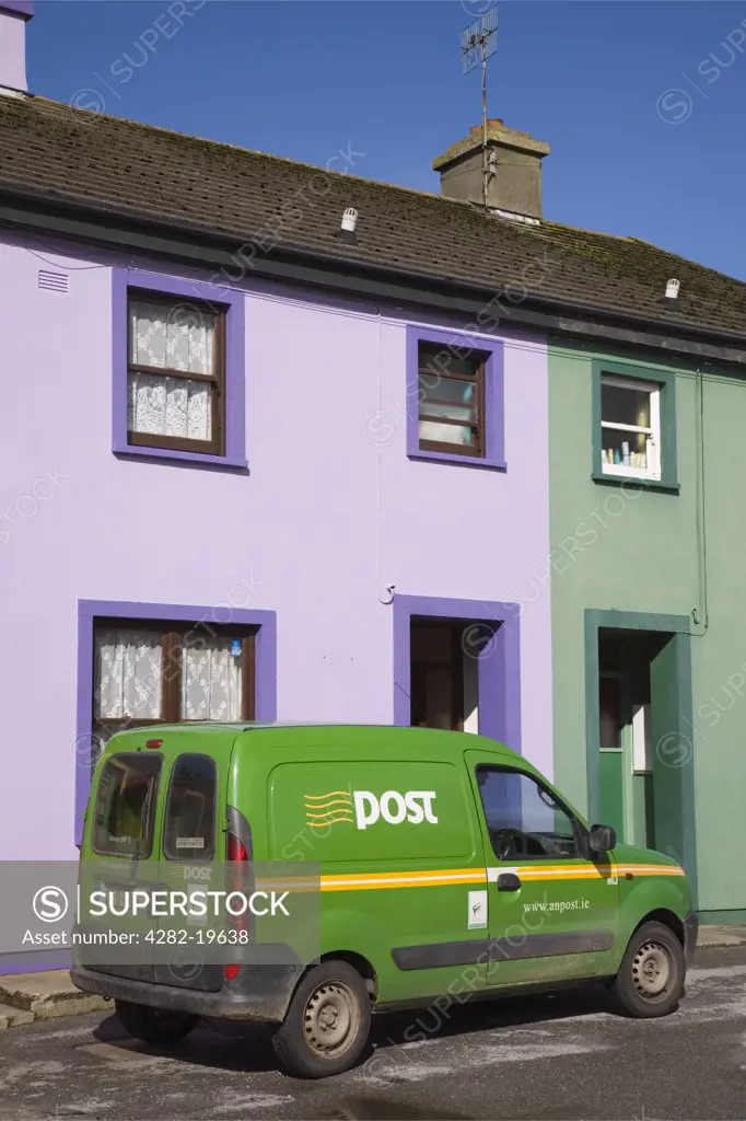 Republic of Ireland, County Cork, Eyeries. Green post van outside colourful traditional houses in main street of village on Ring of Beara tourist route round Beara peninsula.