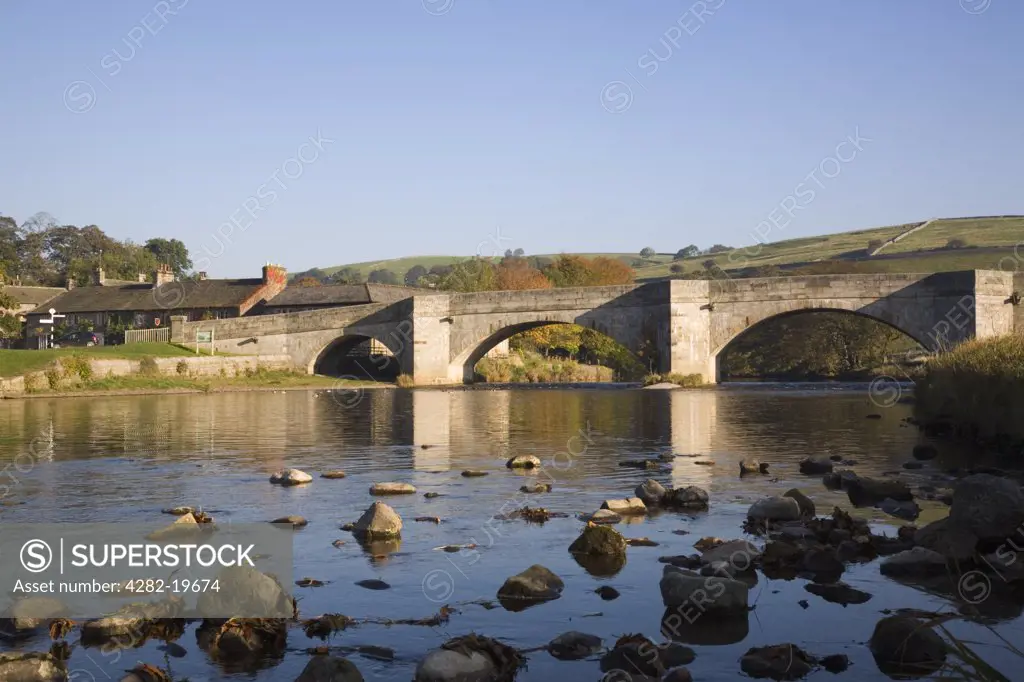 England, North Yorkshire, Burnsall. The River Wharfe and stone arched bridge in Burnsall in the Yorkshire Dales National Park.